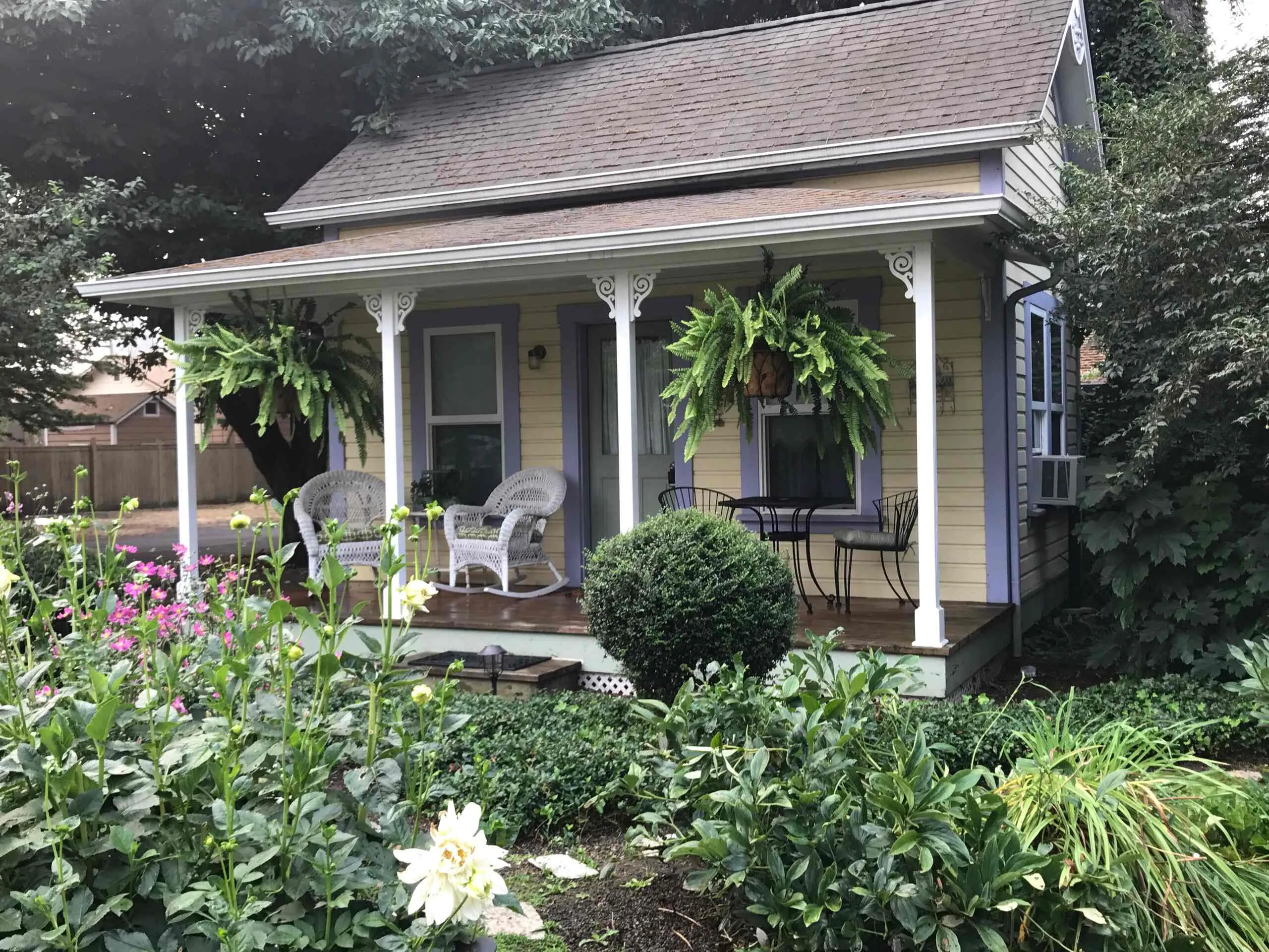 The cottage porch framed by dahlias and greenery