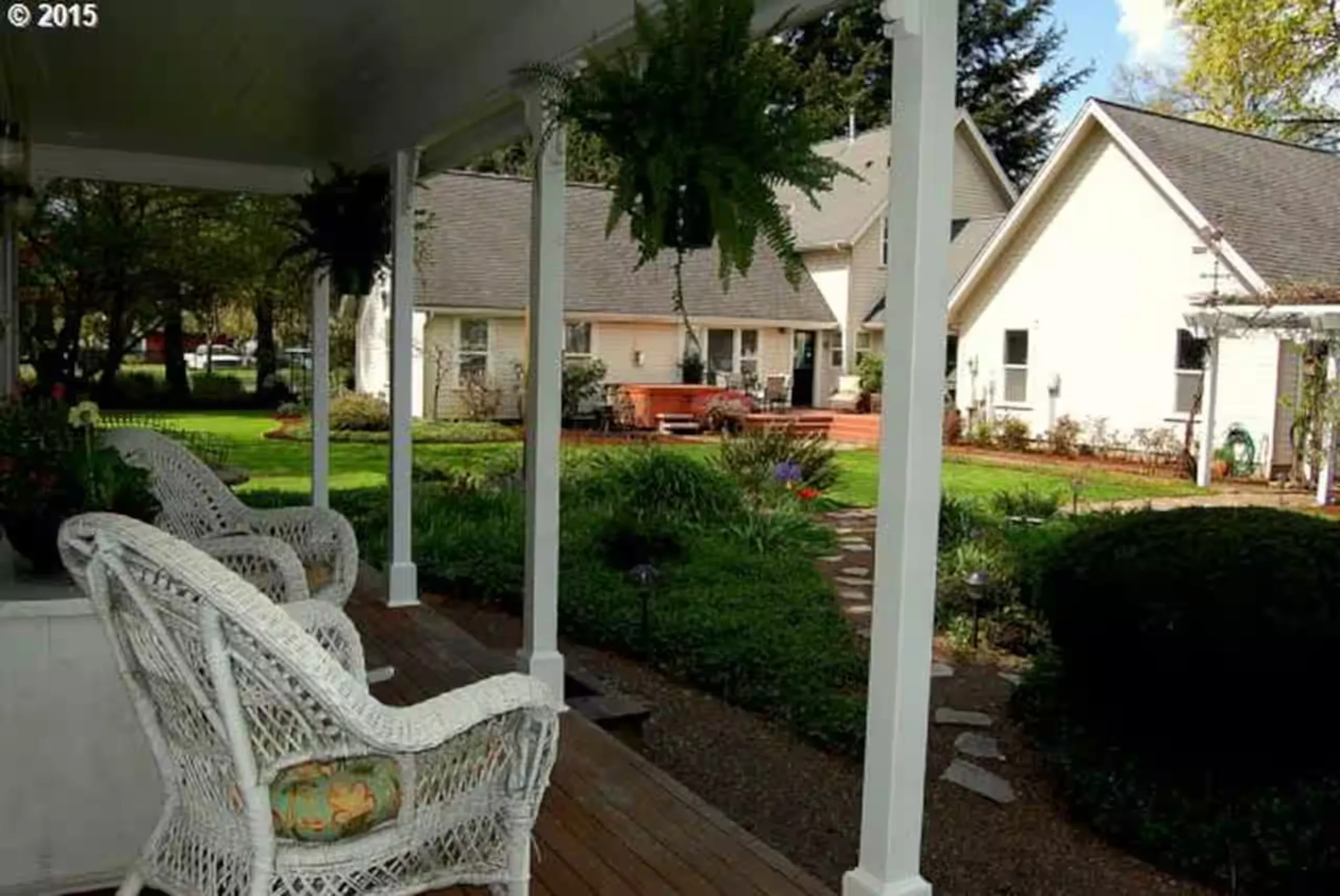 Front porch with wicker chairs and hanging ferns