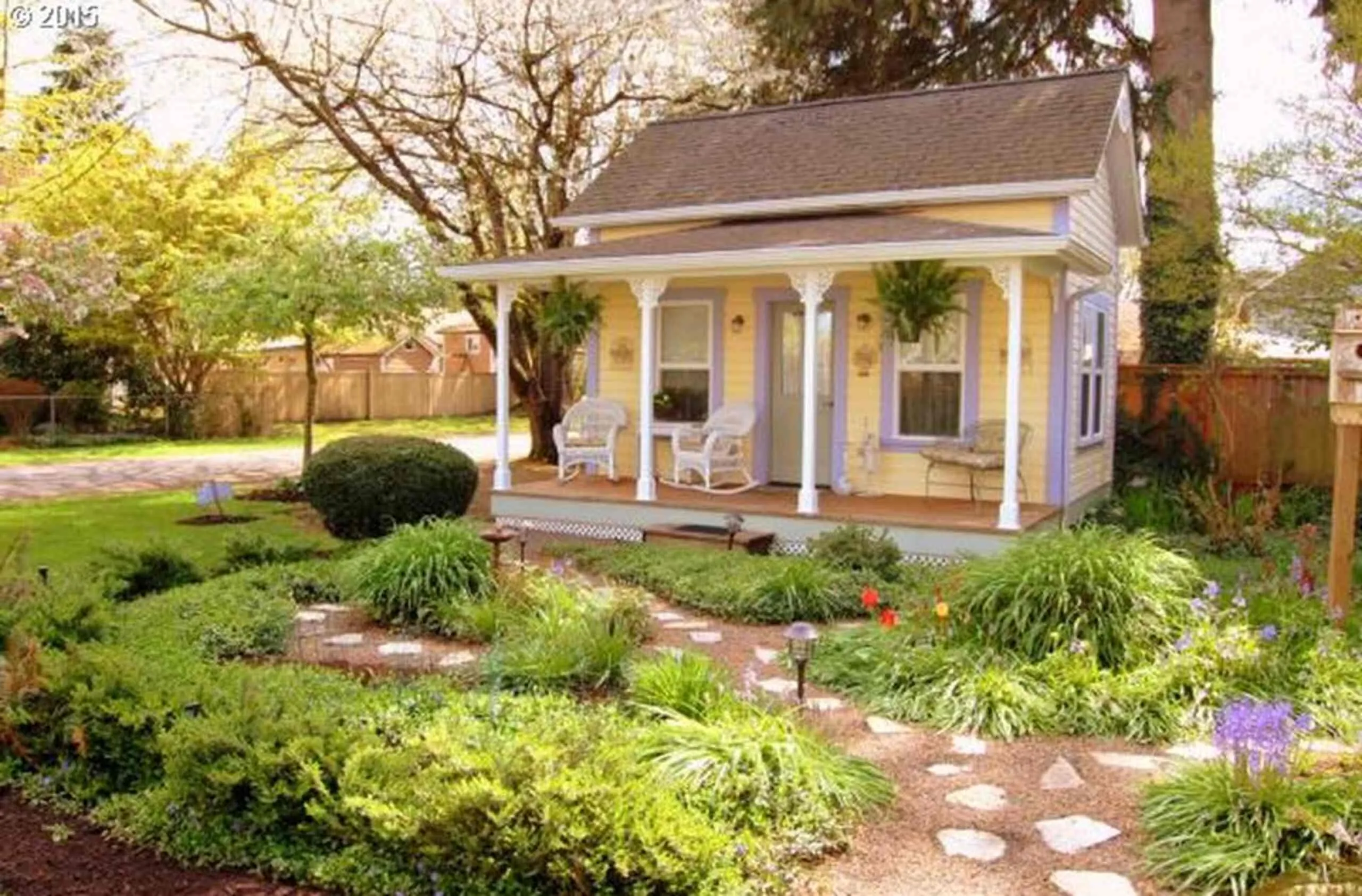 The yellow cottage with its wraparound porch and flowering garden